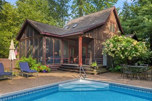 A wooden cabin with a swimming pool, outdoor seating, and a garden. - (2027 OPEN!) Gorgeous Union Pier Home With Private Pool! (Union Pier)