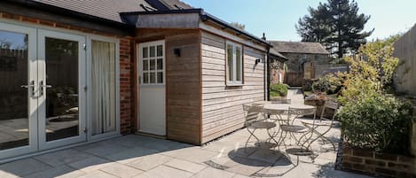 A house with a patio area, a sliding glass door, and a small garden.
