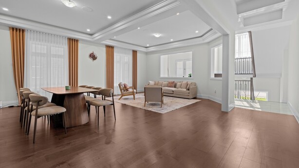 A spacious living area with a dining table, sofas, and a staircase leading to an upper floor. - GlobalStay 4 Bedrooms House in Brampton (Brampton)