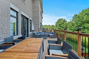 Terraza con mobiliario exterior, un edificio de ladrillo y vistas al verdor.