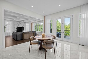 Un amplio salón con una mesa de comedor, sofás y una televisión.