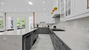 A modern kitchen with a marble countertop, stainless steel appliances, and a view of the outdoors. - GlobalStay 4 Bedrooms House in Brampton (Brampton)