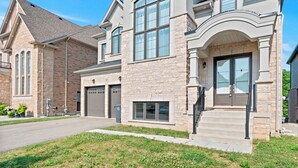 A two-story house with a stone facade, large windows, and a garage. - GlobalStay 4 Bedrooms House in Brampton (Brampton)