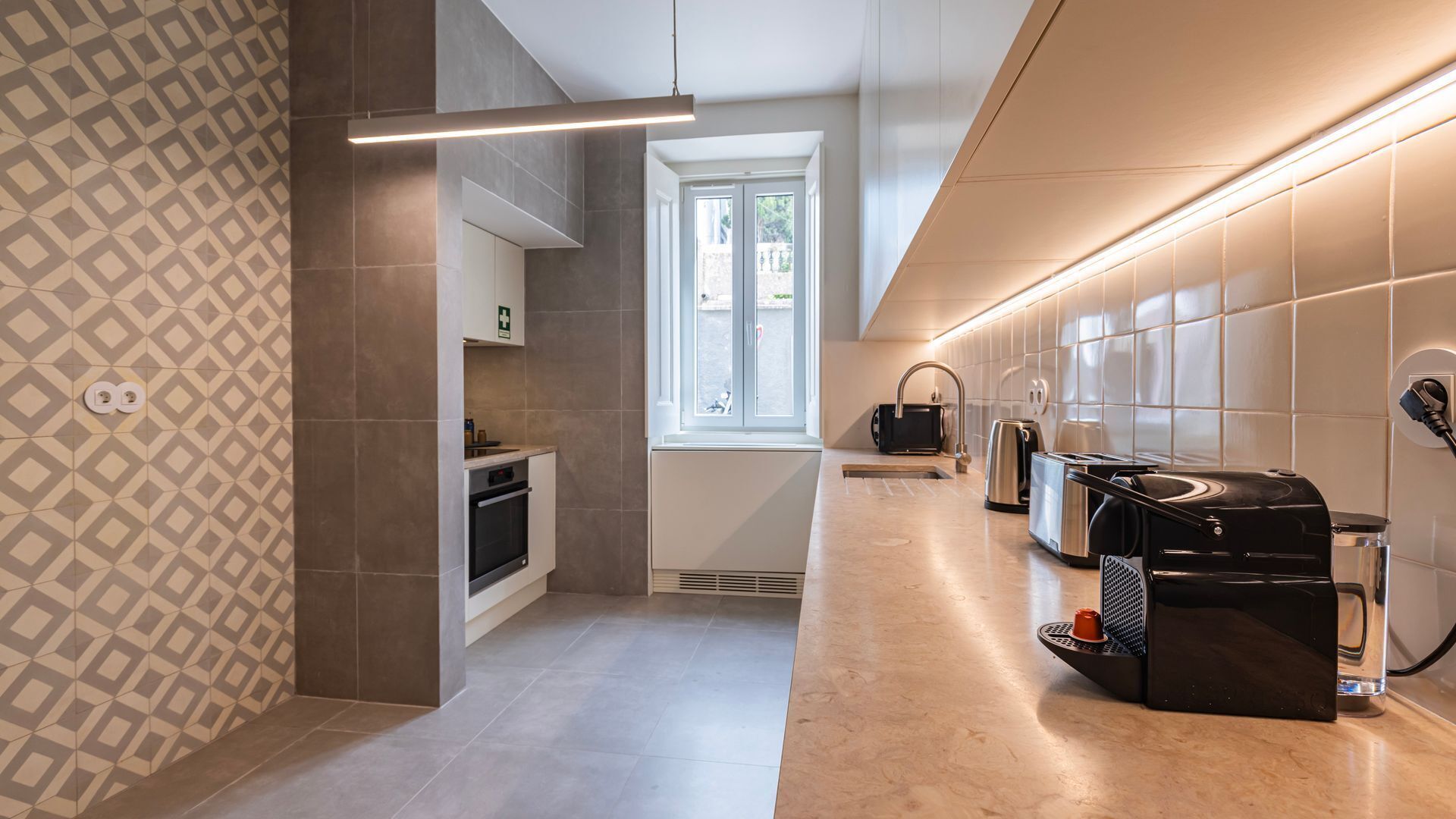 Eine moderne Küche mit Backofen, Wasserkocher, Toaster und Kaffeemaschine.