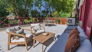 An outdoor seating area with wooden furniture, a table, and a sofa. - Casa da Biblioteca - Apt I - by LovelyStay (Sintra)