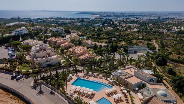 An aerial view of a resort with a swimming pool, sun loungers, and a view of the sea. - Casa V2 Solarenga perto de Ferragudo by Lovelystay (Ferragudo)