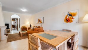 A modern living room with a dining area, featuring a sofa set, a coffee table, and a dining table with chairs. - Casa V2 Solarenga perto de Ferragudo by Lovelystay (Ferragudo)