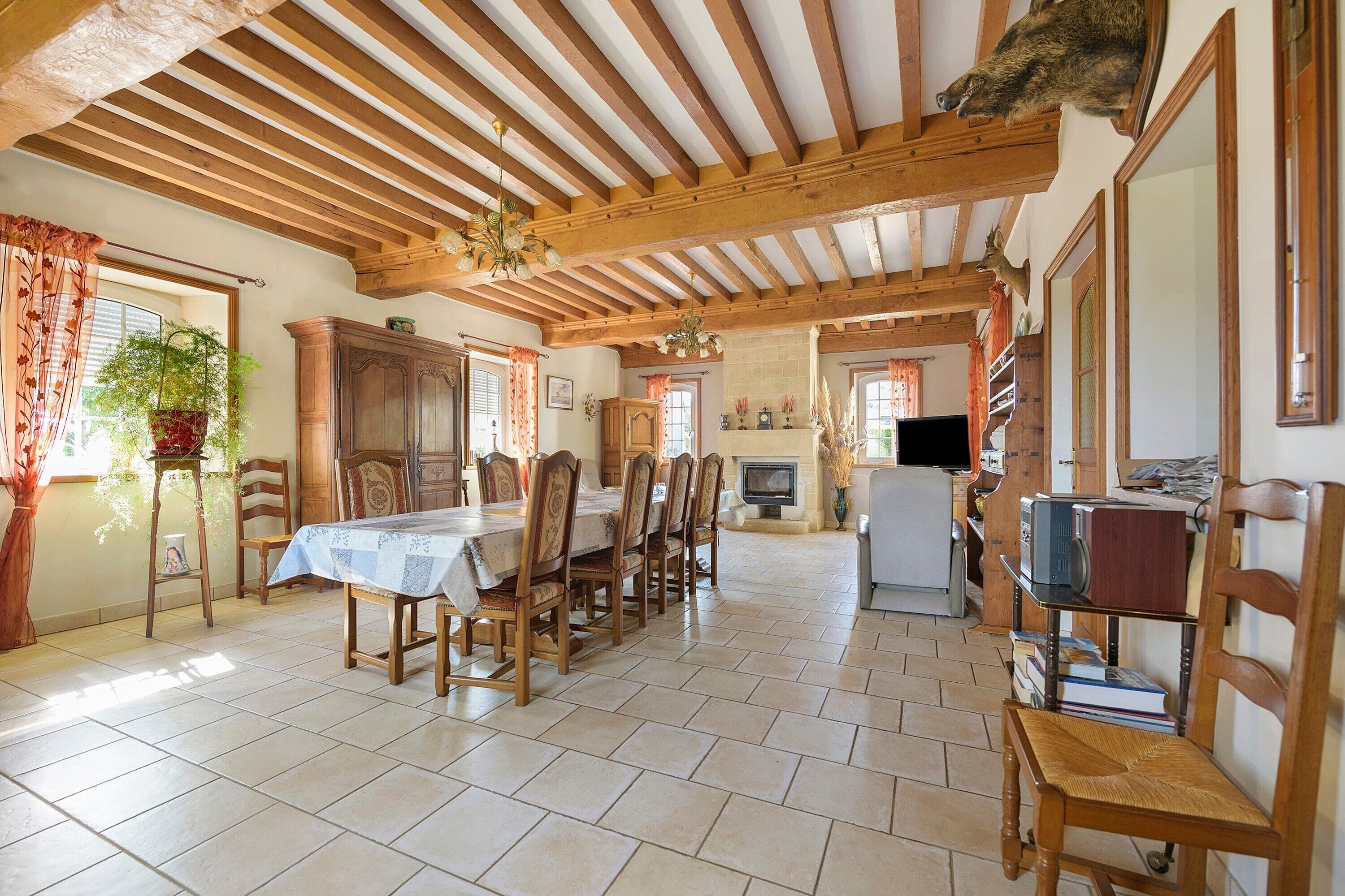 A spacious dining area with a wooden table and chairs, a fireplace, and a television.