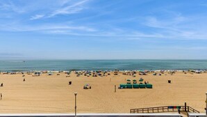 Ein Strand mit Menschen, Sonnenschirmen und Liegestühlen.