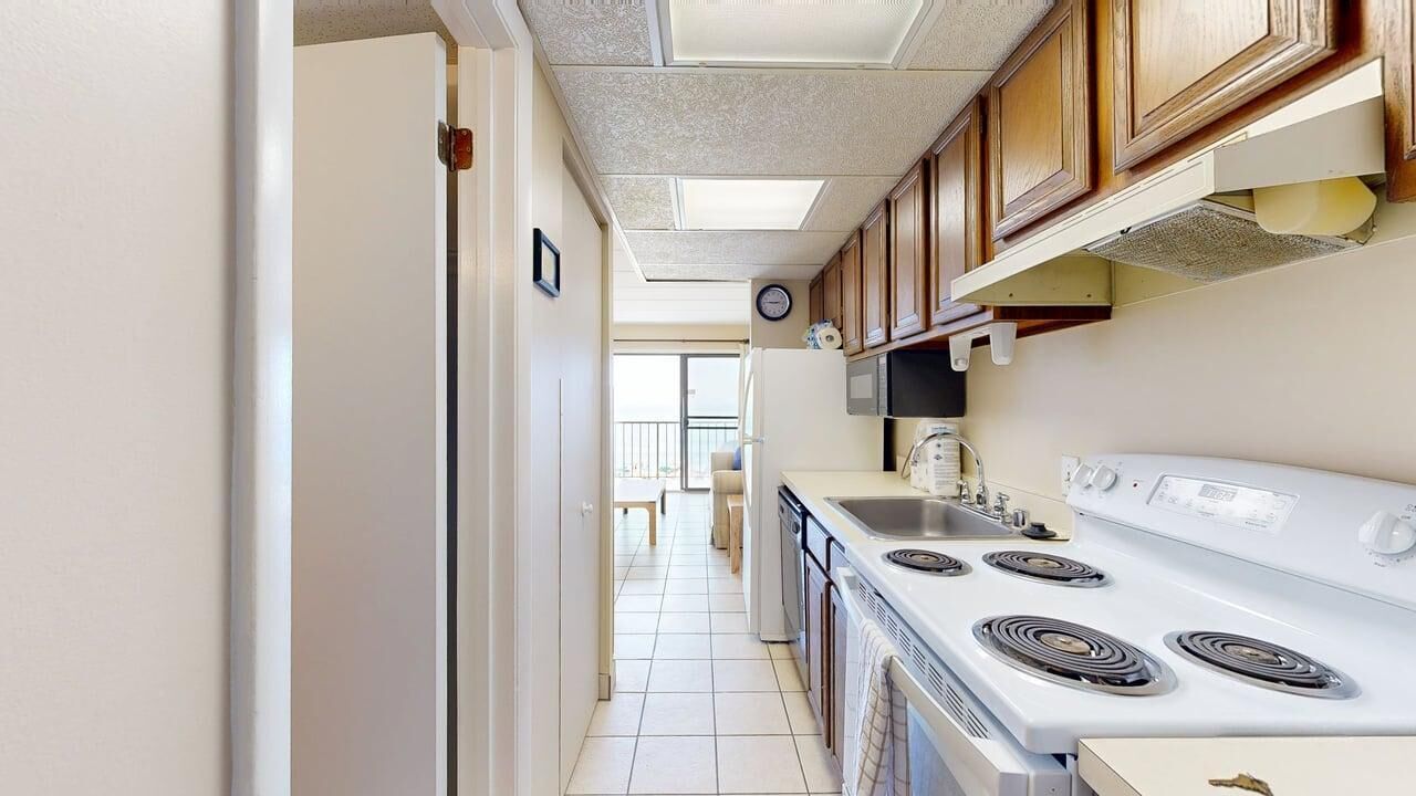 A kitchen with a stove, microwave, and cabinets.