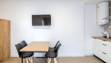 Een moderne keuken met witte kasten, een houten aanrechtblad en een ingebouwde oven.