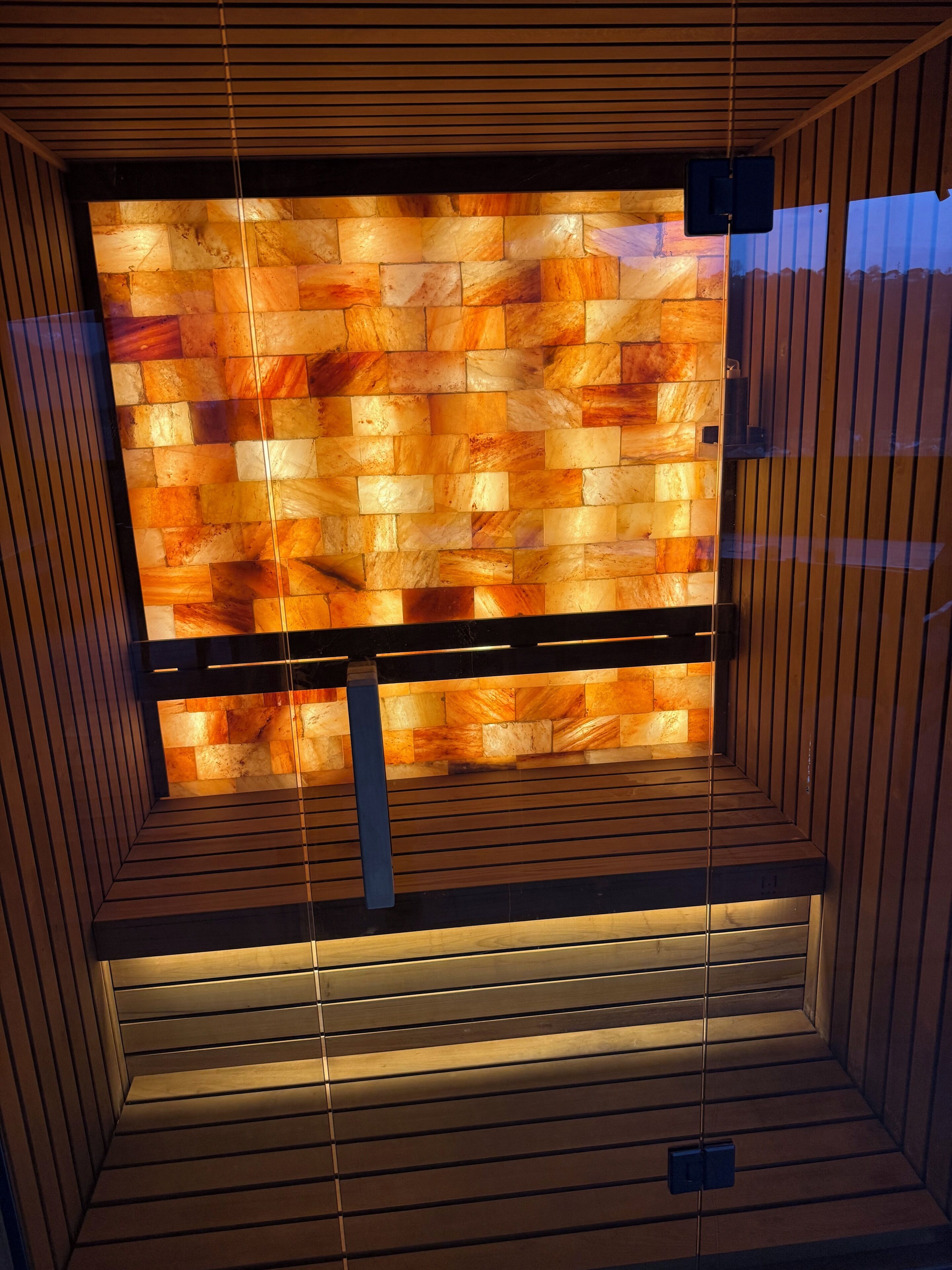 A modern interior with a wooden slatted ceiling and a wall with a mosaic tile pattern.