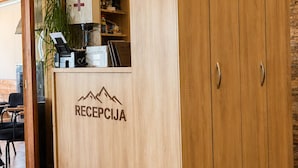 A reception area with a wooden desk, a reception counter, and a large wardrobe. - Rooms & Spa BJELASICA (Bijelo Polje)