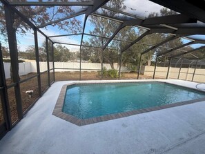 A covered swimming pool with a clear view of the surrounding area. - Beautiful 2/2 Pool Home in Spring Hill (Spring Hill)