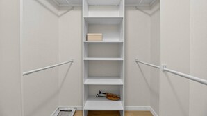 A narrow walk-in closet with white shelving, a wooden shoe rack, and a white door. - Beautiful 2/2 Pool Home in Spring Hill (Spring Hill)