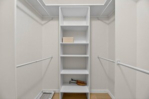 A narrow walk-in closet with white shelving, a wooden shoe rack, and a white door. - Beautiful 2/2 Pool Home in Spring Hill (Spring Hill)