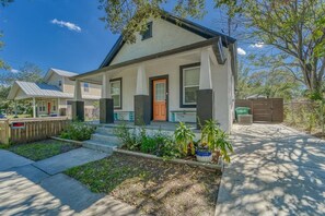 A residential house with a front porch, a door, and a small garden. - Modern West Tampa Bungalow - Live & Work In Style (Tampa)