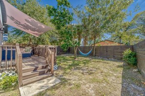 A backyard with a wooden deck, a hammock, and a fenced area. - Modern West Tampa Bungalow - Live & Work In Style (Tampa)