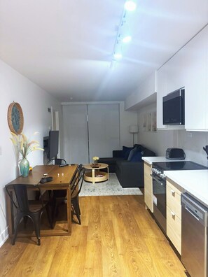 Un espacio habitable compacto con comedor, kitchenette y sofá.