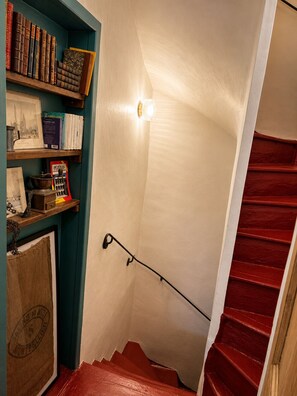Eine Treppe mit roter Handlauf und einer Wandleuchte.