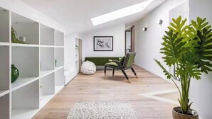 A modern interior with white shelving, a green chair, a bean bag, and a large plant. - JUST 250 METRES FROM THE FAMOUS BOULEVARD DE LA CROISETTE AND ITS SANDY BEACHES (Cannes)