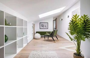 A modern interior with white shelving, a green chair, a bean bag, and a large plant. - JUST 250 METRES FROM THE FAMOUS BOULEVARD DE LA CROISETTE AND ITS SANDY BEACHES (Cannes)