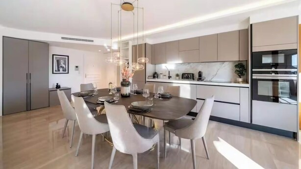 A modern kitchen with a central island, built-in appliances, and a dining area with a round table and chairs. - JUST 250 METRES FROM THE FAMOUS BOULEVARD DE LA CROISETTE AND ITS SANDY BEACHES (Cannes)