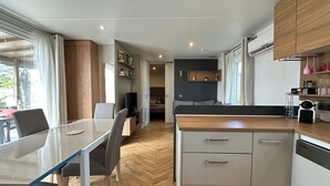 A compact kitchen with a dining area, wooden cabinets, and a built-in dishwasher.