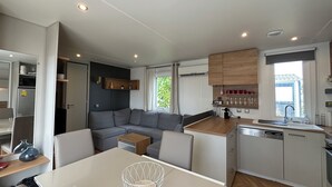 A compact living space with a kitchenette, a dining area, and a sofa.