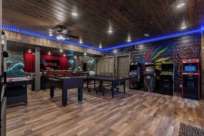 A room with a pool table, a foosball table, and arcade games. - 8-Bedroom Cabin with Themed Indoor Pool, Theater & Arcade Near Pigeon Forge (Sevierville)
