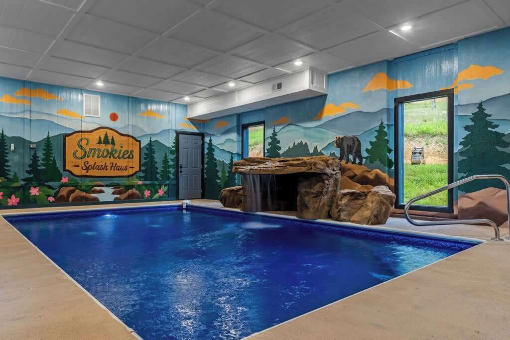 Ein Swimmingpool mit Wandgemälde der Smokies, einem Wasserfall und einer zur Außenwelt führenden Tür.