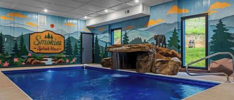 Ein Swimmingpool mit Wandgemälde der Smokies, einem Wasserfall und einer zur Außenwelt führenden Tür.
