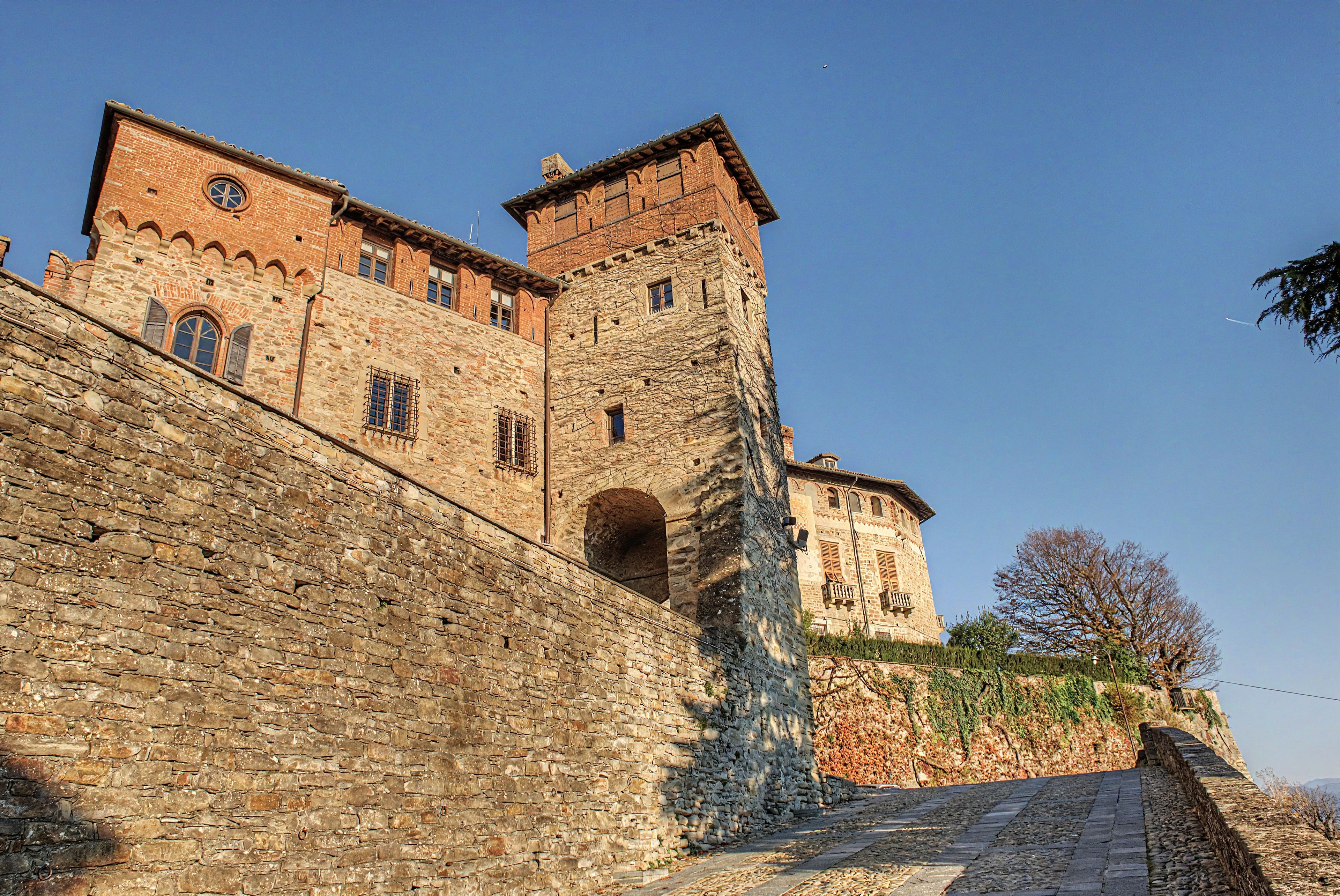 A historic stone building with a prominent tower and arched windows.