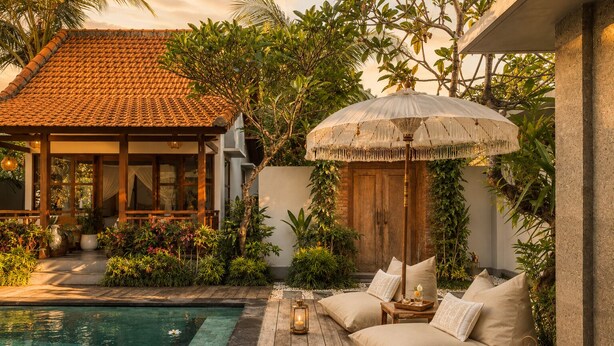 A poolside area with a wooden deck, a covered seating area, and a large umbrella. - Pavilion Pool Villa. Walk to Beach (Kecamatan Mengwi,)