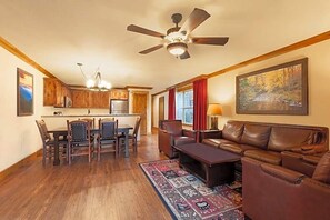 Ein Wohnzimmer mit einem braunen Ledersofa, einem Couchtisch und einem Essbereich mit einem Holztisch und Stühlen.