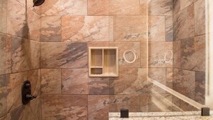 Un bagno con doccia, lavandino e specchio.