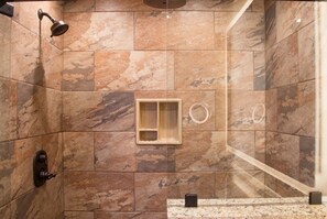 Ein Badezimmer mit Dusche, Waschbecken und Spiegel.