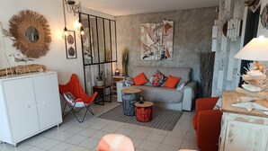 A modern living room with a sofa, chairs, a dining table, and a kitchen area with cabinets. - Port Fréjus: harbor view, spacious 1-bedroom apartment (47m²), air conditioning, swimming pool—for 4 lucky guests. (Fréjus)
