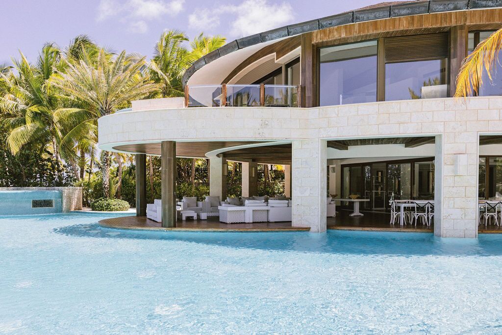 A modern resort with a pool, outdoor seating, and a two-story structure.