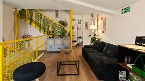 Un interior moderno con una escalera, un sofá, una mesa de centro y una estantería.