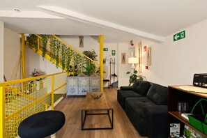 A modern interior with a staircase, a sofa, a coffee table, and a bookshelf.