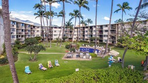 A hotel with multiple balconies, a swimming pool, and palm trees. - Oceanfront Maui Condo, Whale Watching, Beach Access & Endless Views (Wailuku)
