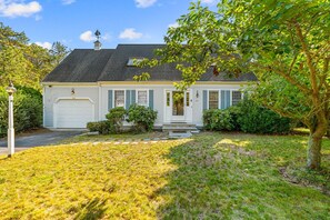 Een gelijkvloers huis met garage, voortuin en een verzorgd gazon.