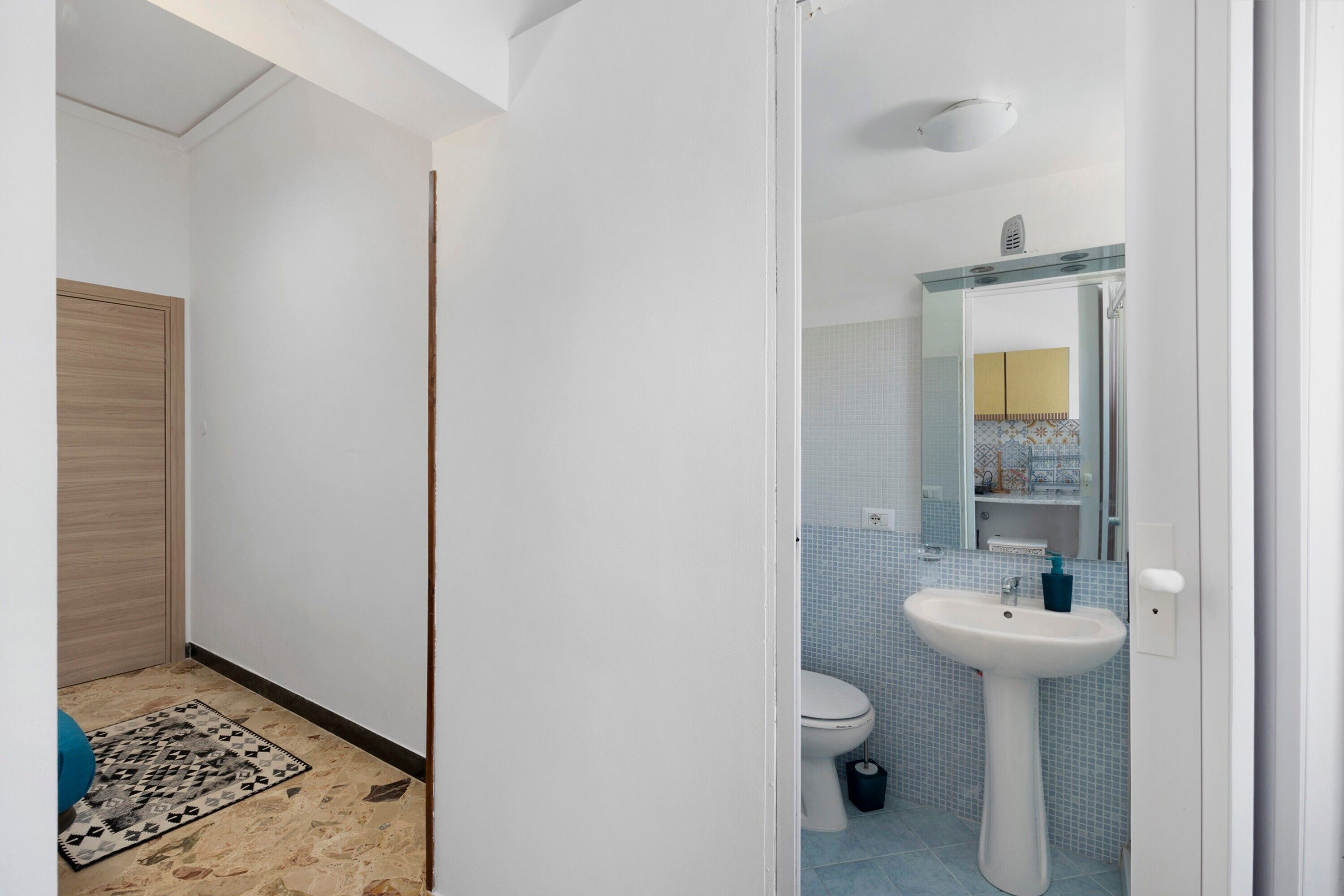 Ein Badezimmer mit Waschbecken, Toilette und Spiegel.