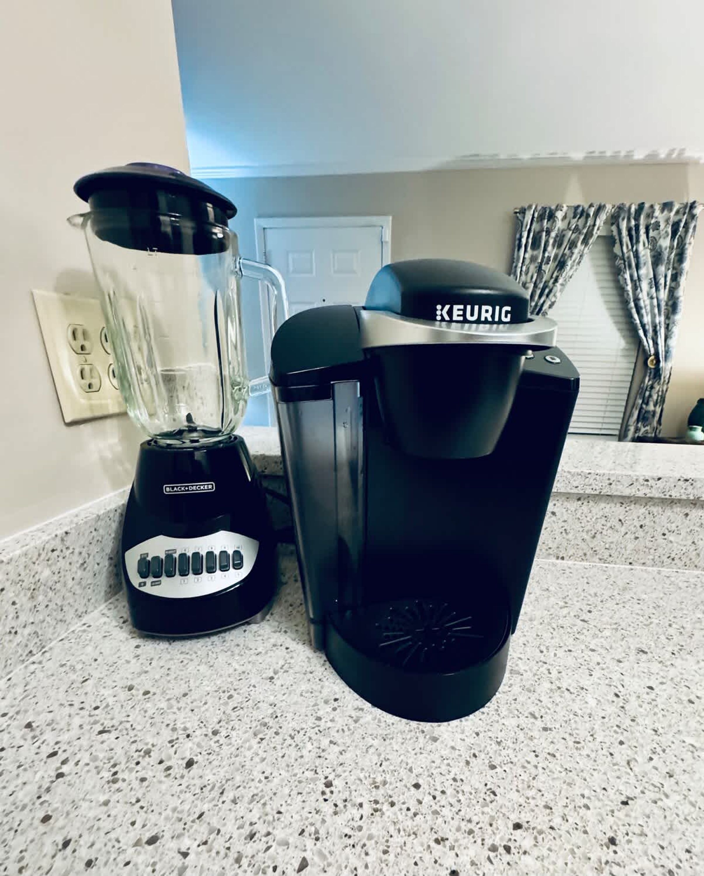 A kitchen with a blender and a Keurig coffee maker on the counter.