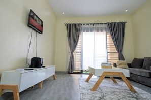 Ein modernes Wohnzimmer mit einer weißen Unterhaltungseinheit, einem grauen Sofa und einem Couchtisch.