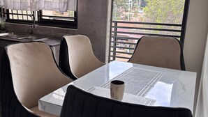 Una cocina moderna con un lavamanos, una mesa de comedor con sillas y vistas al exterior.