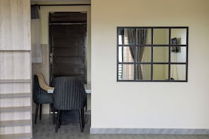 A room with a closed door, a window with a curtain, and two chairs. - Our Beautiful Home,2 Bedrooms. Close to shops, amenities & Ndere Cultural Centre (Kisasi)