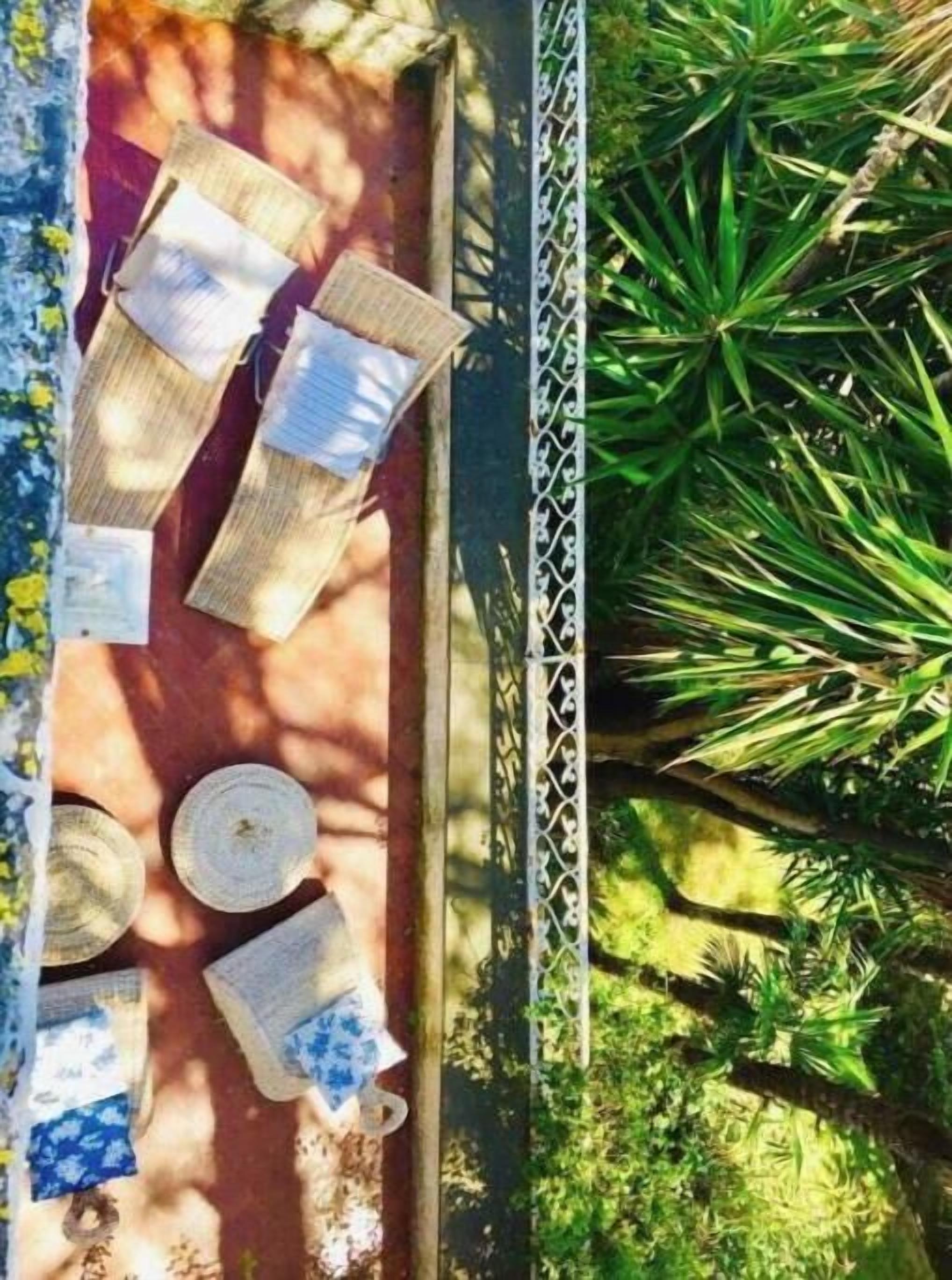 A table set outdoors with a metal railing, surrounded by greenery.