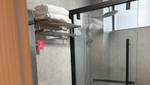 Ein modernes Badezimmer mit einer Glasdusche, einer Toilette und einem Waschbecken.